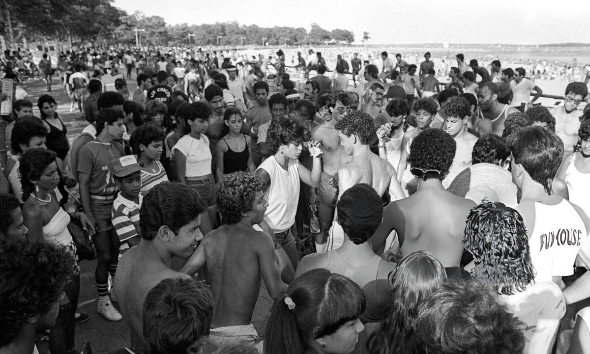 Couple Dancing On The Boardwalk Surrounded By Onlookers At Orchard Beach, Bronx, 1984.