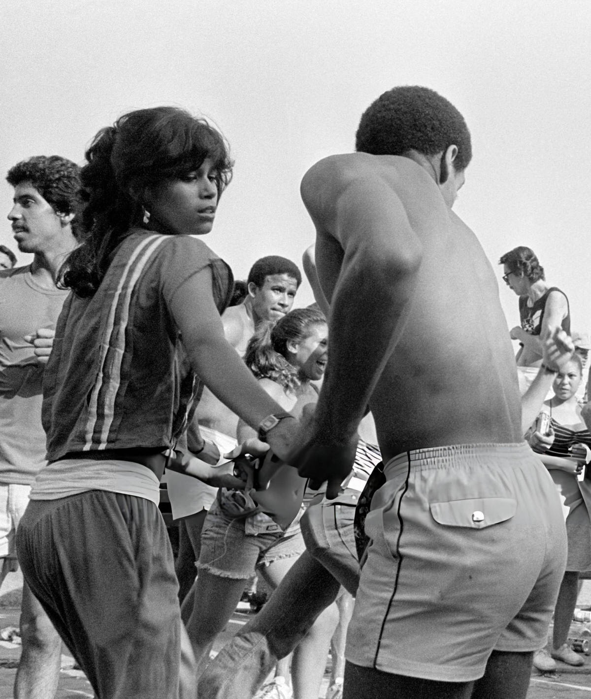 Two People Holding Hands While Dancing On The Boardwalk At Orchard Beach, Bronx, 1983.