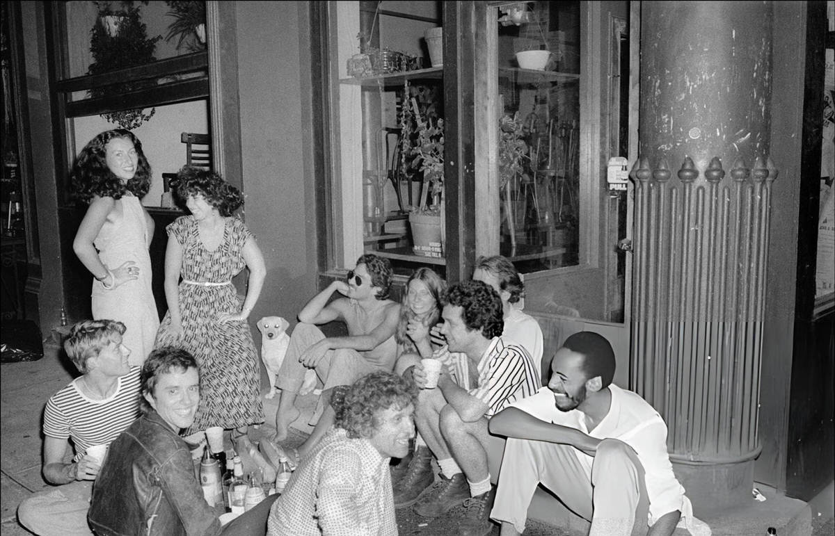 People Having A Party On The Sidewalk Outside The Food Restaurant During A Blackout, Soho, 1977.