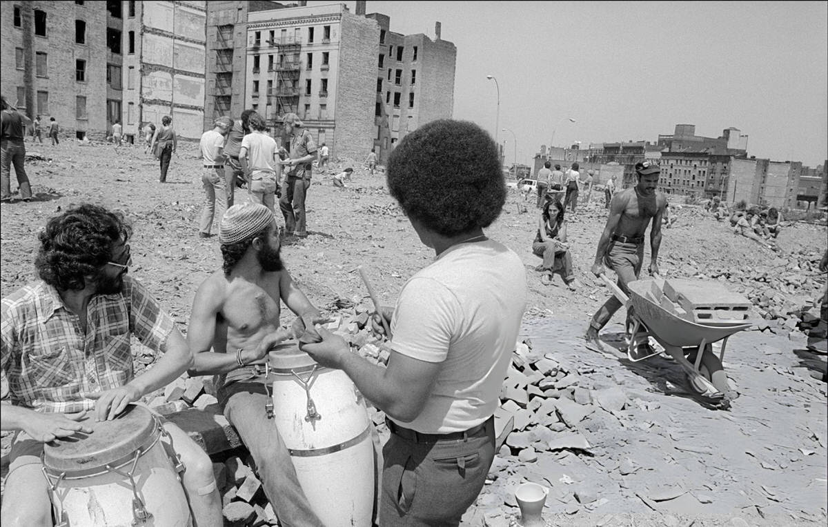 Residents Cleaning Up Abandoned Buildings On Charlotte Street To The Music Of Conga Drummers, South Bronx, 1980.