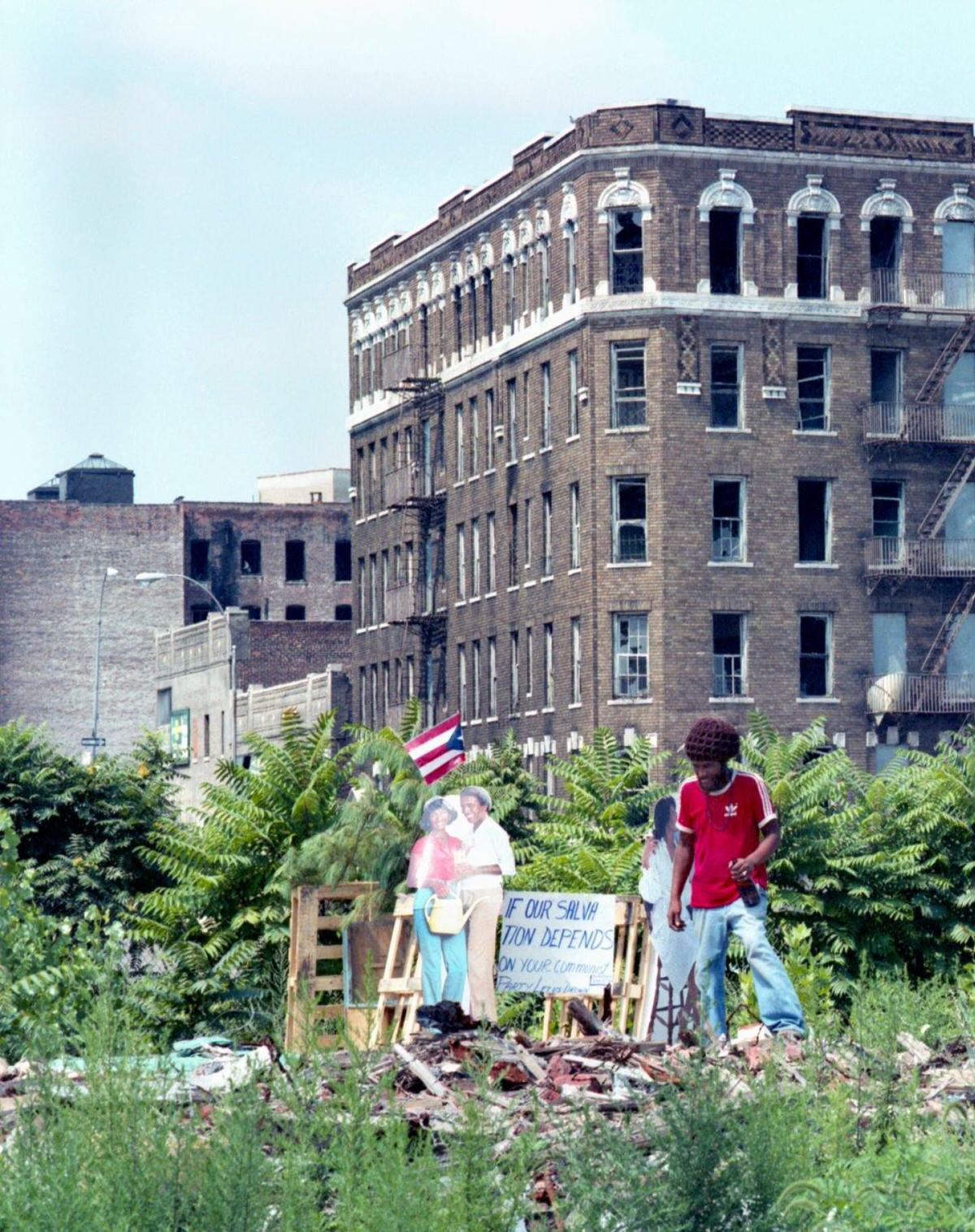 Man Drinking Beer Beside A Community Salvation Sign Amidst Razed Apartment Buildings, South Bronx, 1980.
