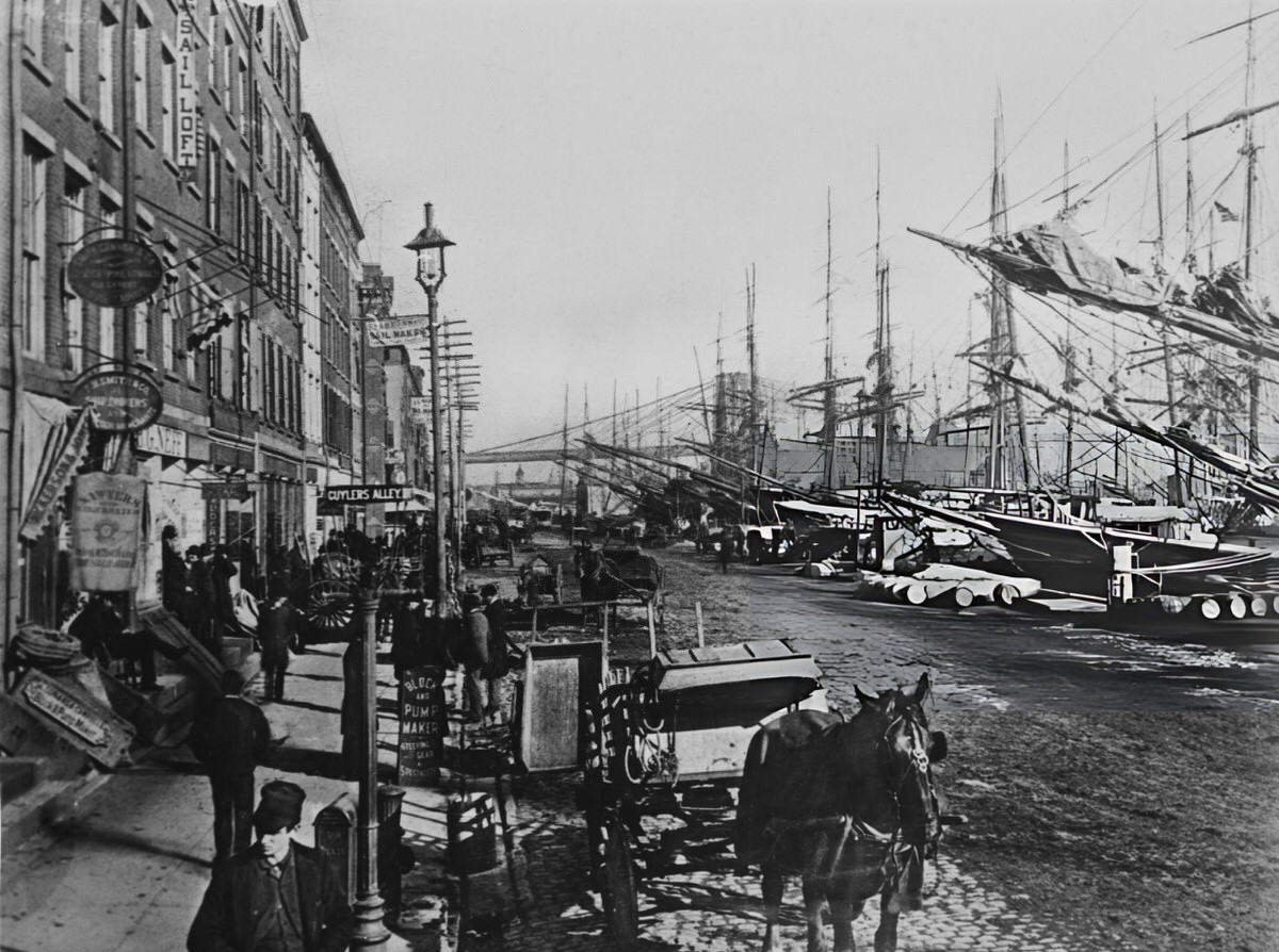 South Street Seaport With Sailing Ships And Carriages, New York, 1883.