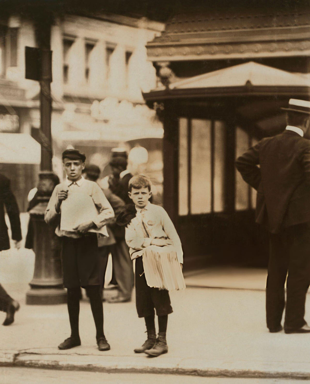Two Young Newsboys Standing Near A Subway Entrance, New York, 1910.