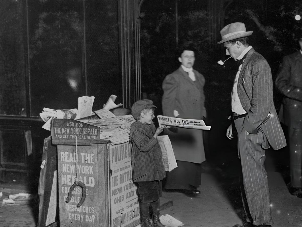 Seven-Year-Old Newsboy Selling A Paper To A Businessman At Columbus Circle, New York, 1910S.
