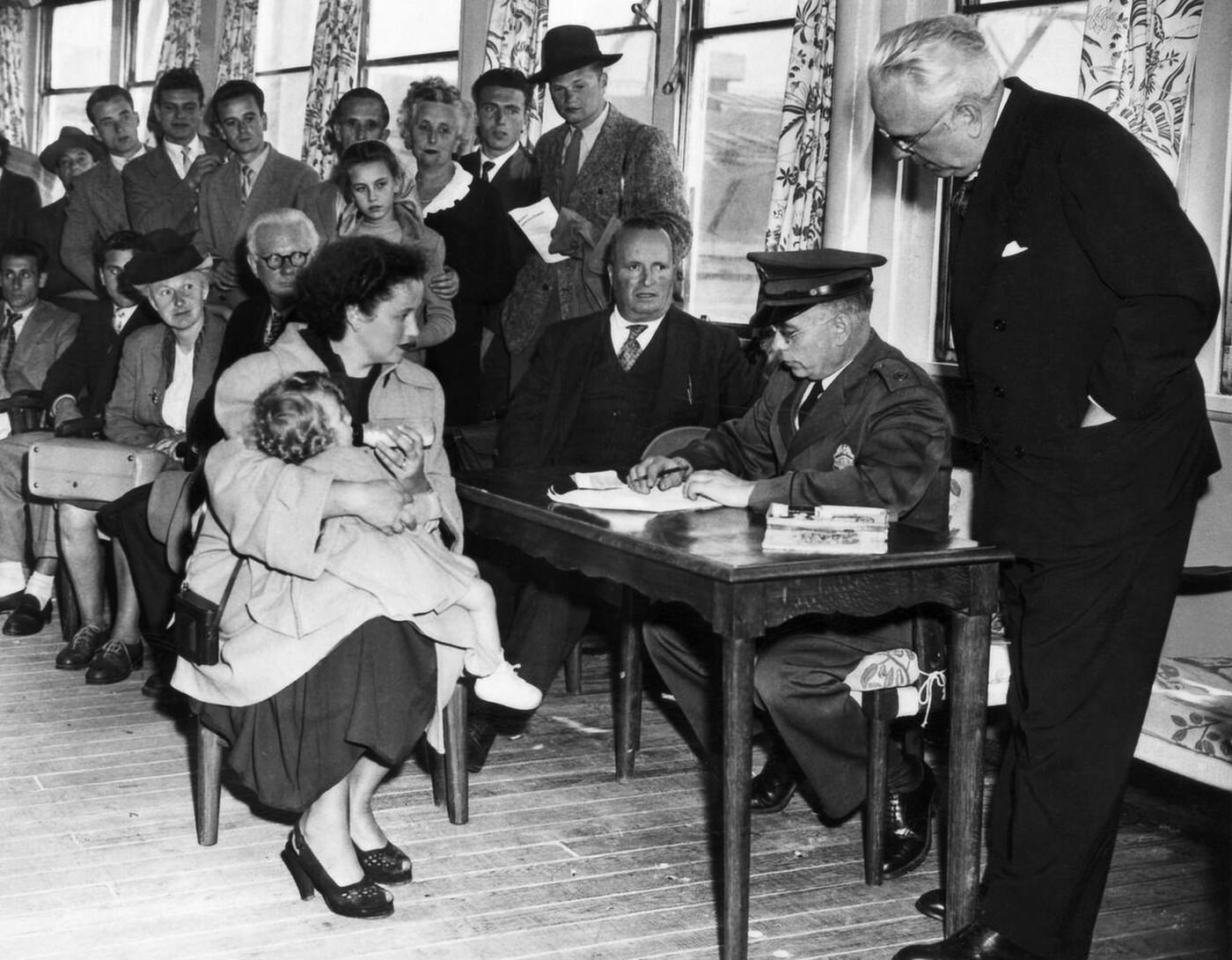 German-Born Wife Of An American Gi And Her Daughter Being Questioned By Inspectors At Ellis Island, 1950