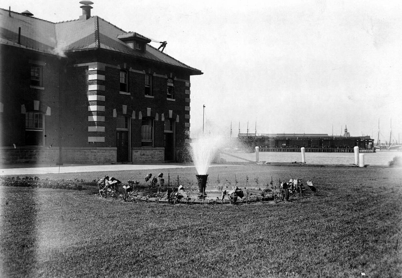 Fountain Spraying Water In Front Of The Ellis Island Immigration Inspection Station, 1907